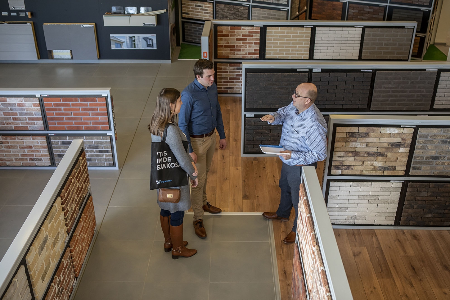 Een expert van Wijckmans geeft een koppel meer informatie over gevelstenen in hun toonzaal.